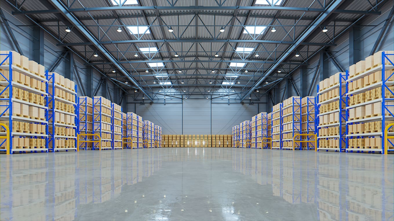 Racked warehouse aisles holding palletised stock under high-bay lighting